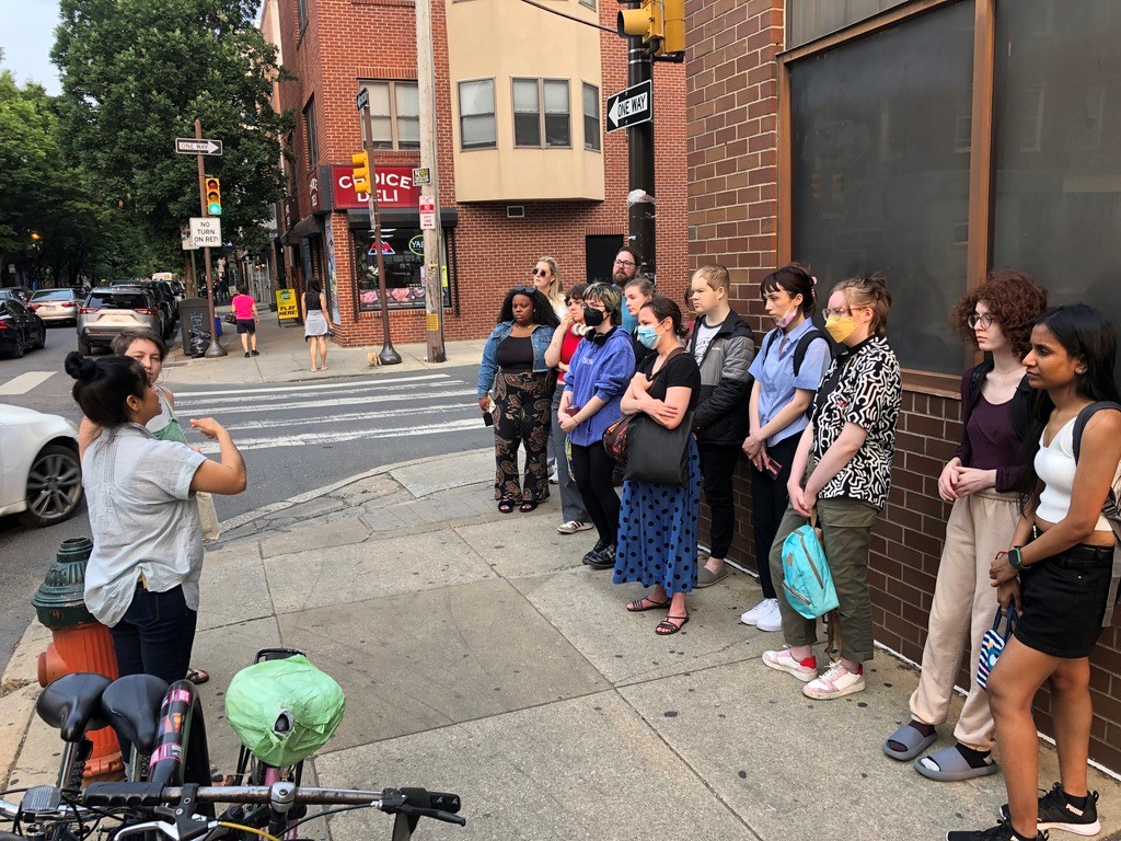Sanctuary Cities Class Spring 2023 students standing outside listening to a speaker